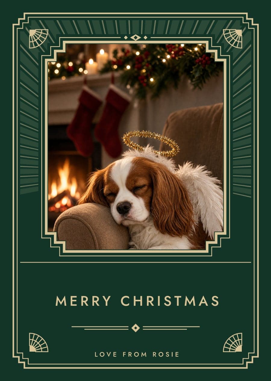 An emerald and gold Art Deco card with a Cavalier King Charles Spaniel asleep by the fire in angel wings
